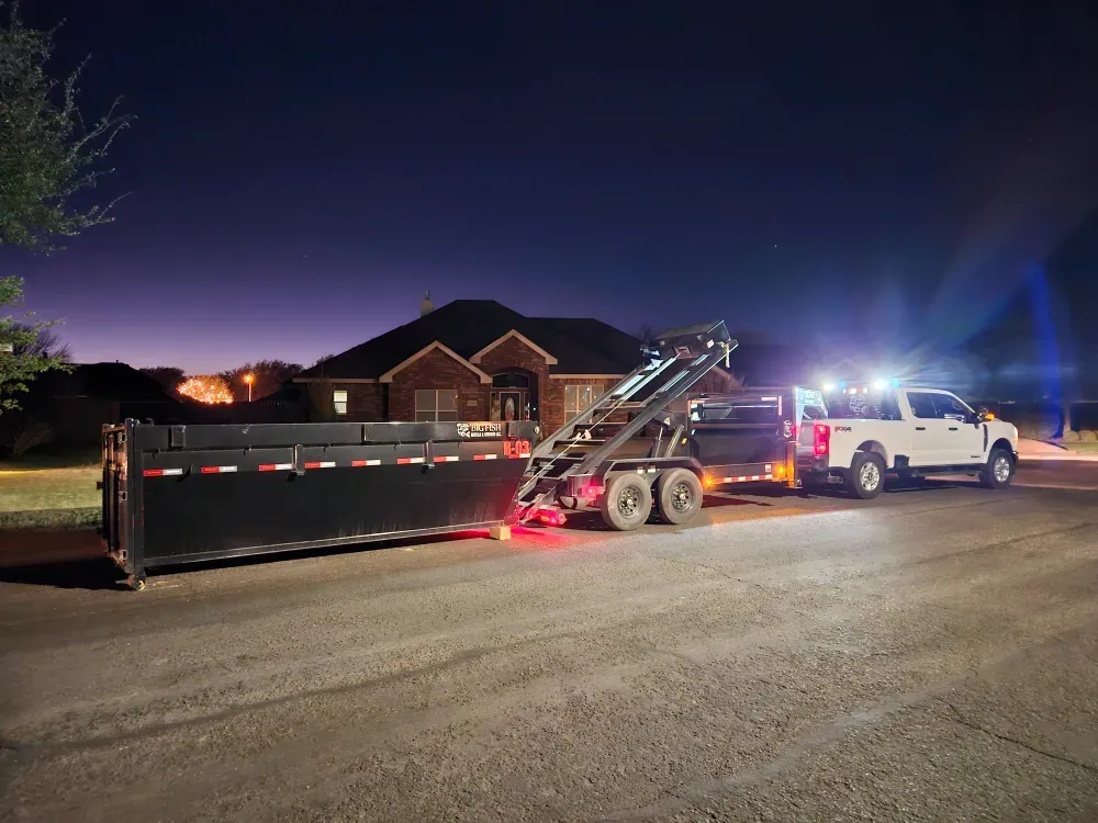 Big Fish Rentals delivering a roll-off container to a house in West Odessa, Texas, after dark.